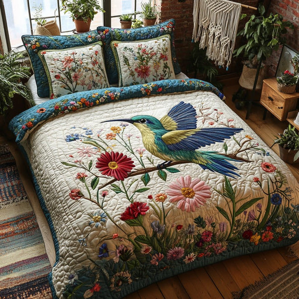Tiny Wings quilted 3-piece bedding set on a made bed with two matching pillow shams