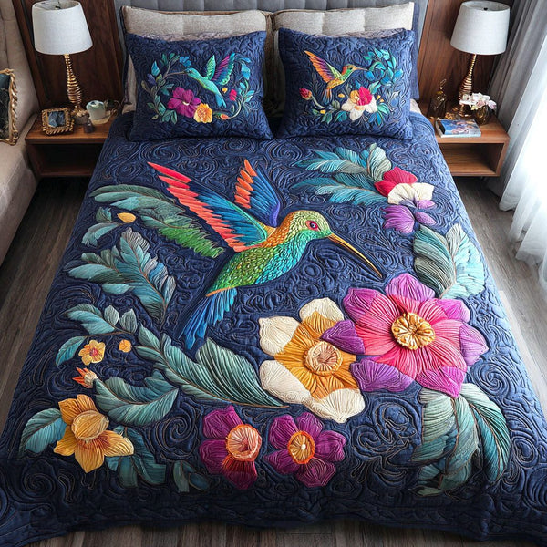 Twilight Hummingbird quilted 3-piece bedding set on a made bed with two matching pillow shams