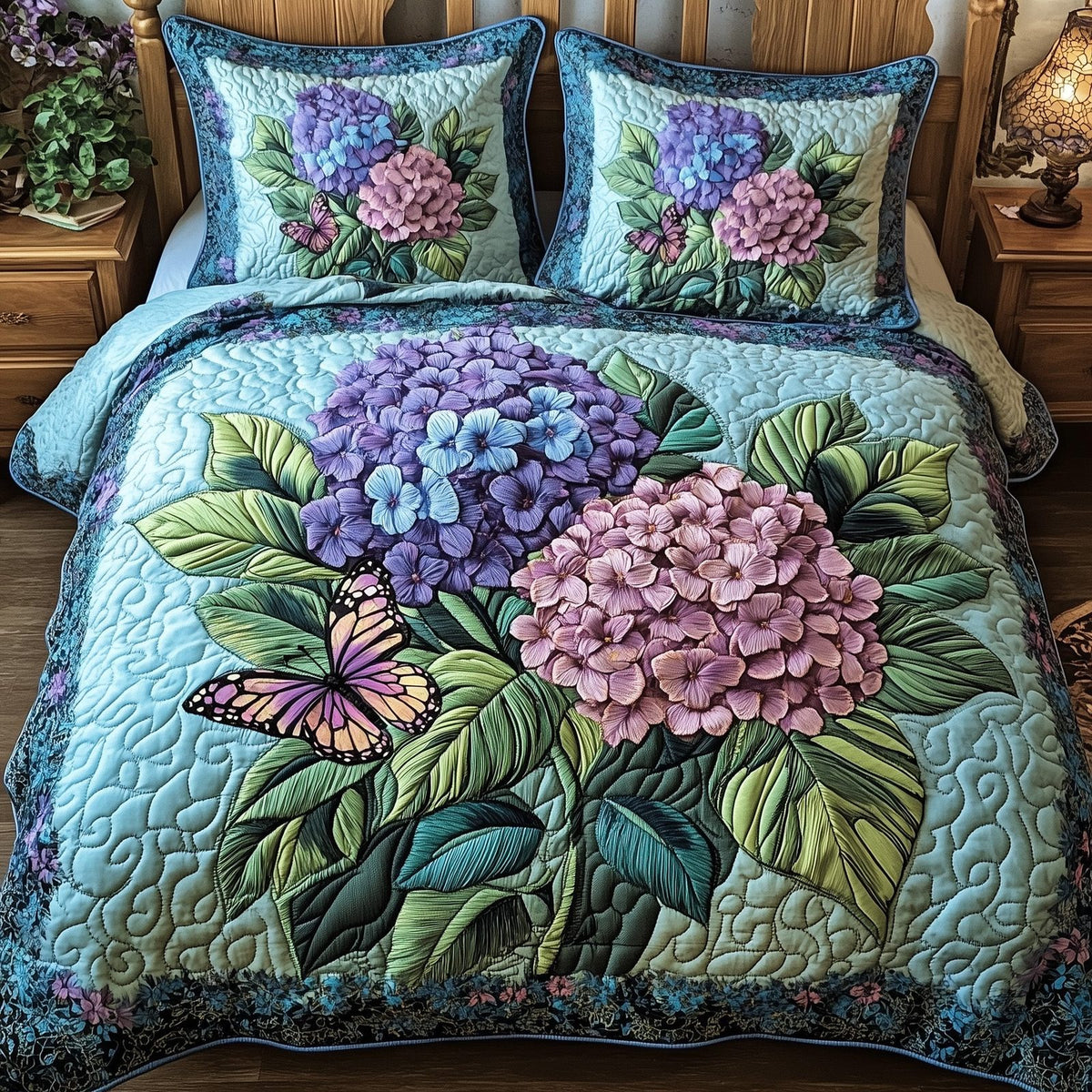 Twilight Hydrangea Garden quilted 3-piece bedding set on a made bed with two matching pillow shams