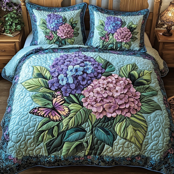 Twilight Hydrangea Garden quilted 3-piece bedding set on a made bed with two matching pillow shams