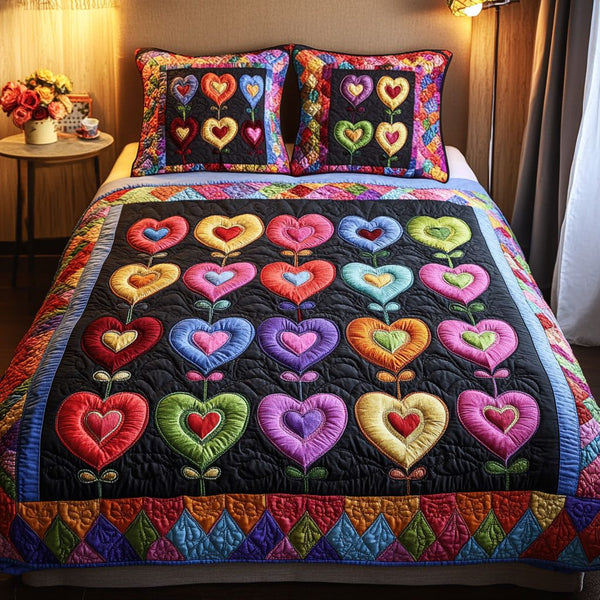 Vibrant Hearts quilted 3-piece bedding set on a made bed with two matching pillow shams