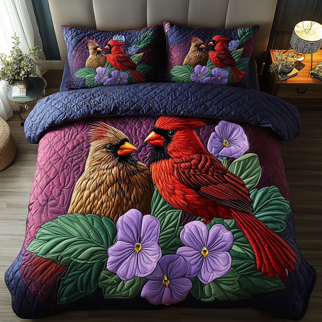 Violet Cardinals quilted 3-piece bedding set on a made bed with two matching pillow shams