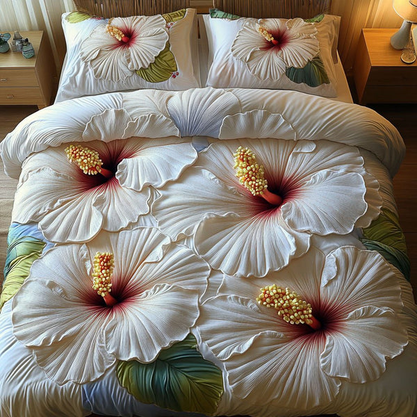 Whispering White Blooms quilted 3-piece bedding set on a made bed with two matching pillow shams