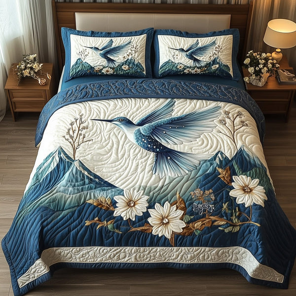 Winter Hummingbird quilted 3-piece bedding set on a made bed in a winter-styled bedroom